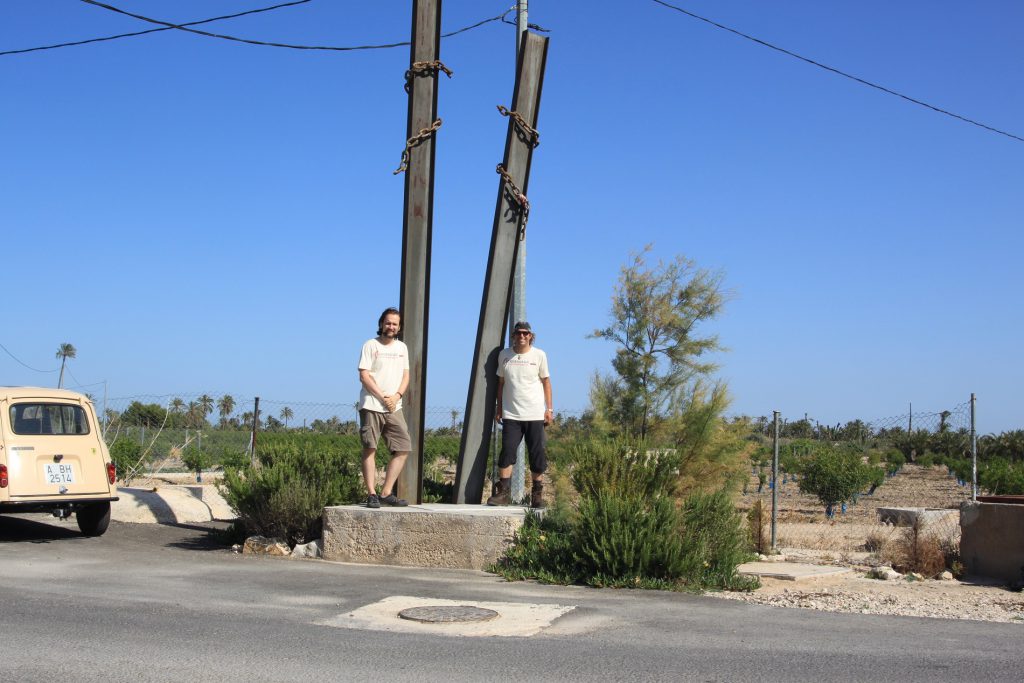 dos senderistas sobre monumento en el camino