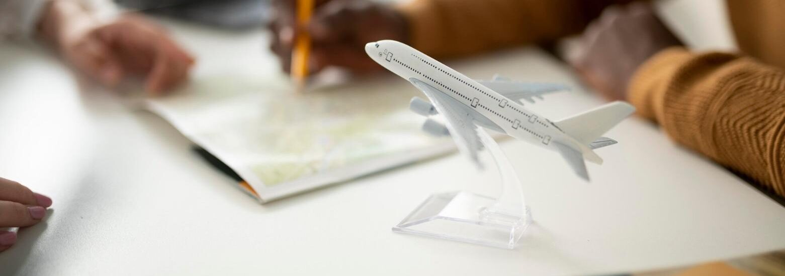 Gente planificando entorno a un escritorio con maqueta de avión en primer término