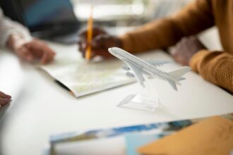 Gente planificando entorno a un escritorio con maqueta de avión en primer término