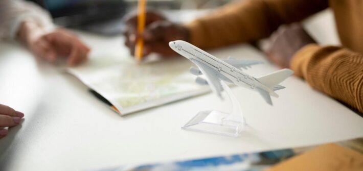 Gente planificando entorno a un escritorio con maqueta de avión en primer término
